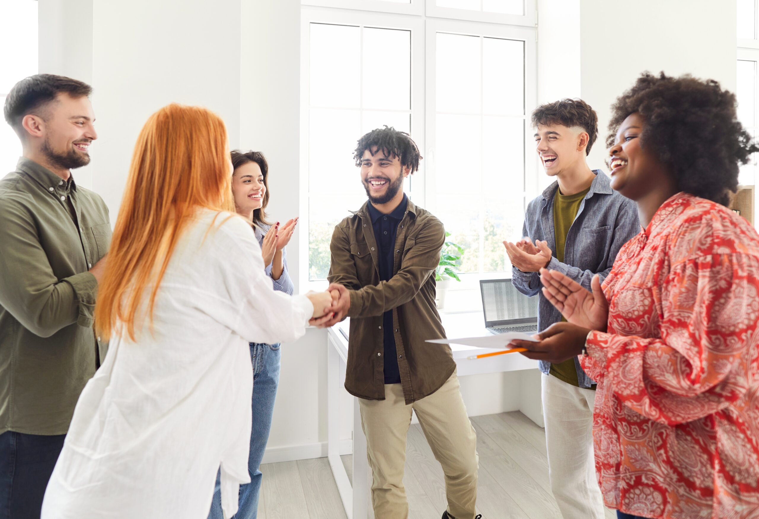 Happy employees welcoming a new hire in the office