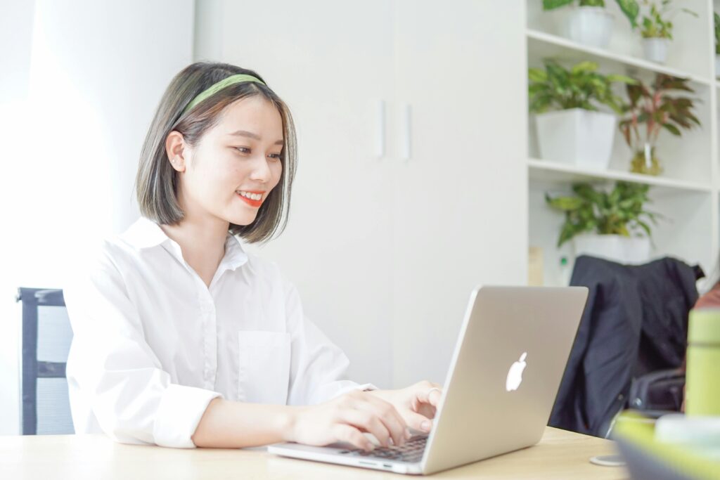 A young woman working on her laptop at a desk, exploring entry-level marketing careers.