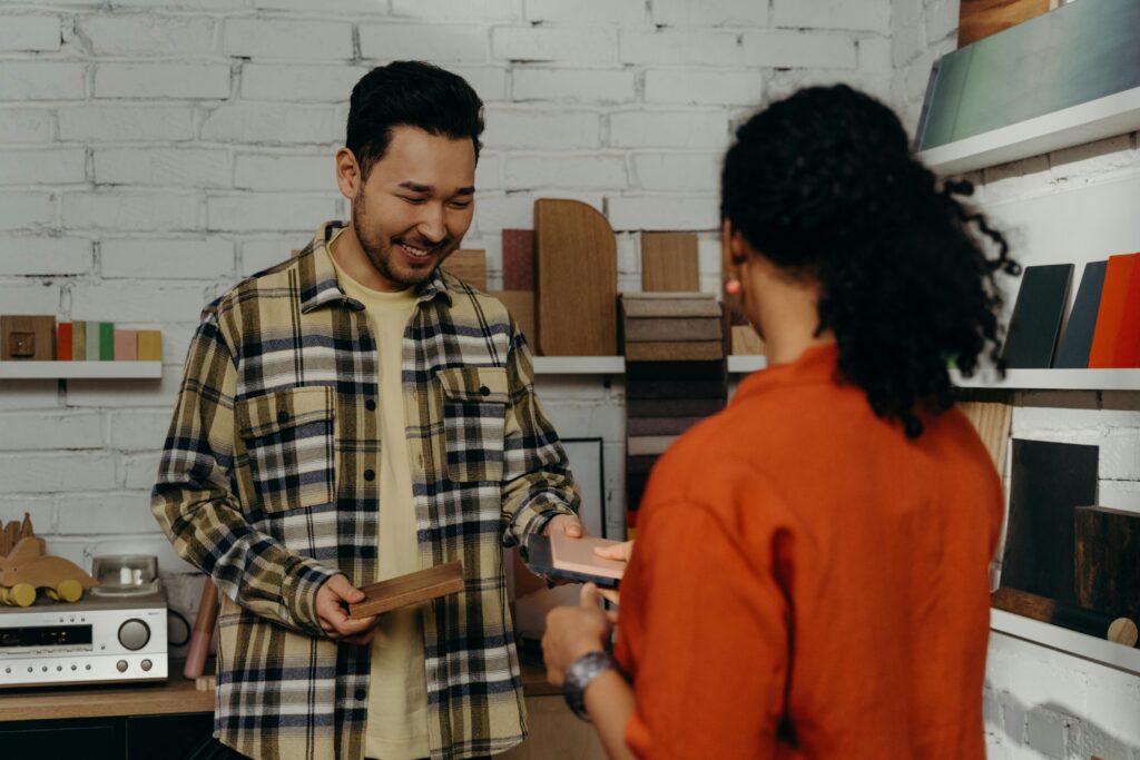 A salesman showing wood samples to a client, demonstrating customer engagement.