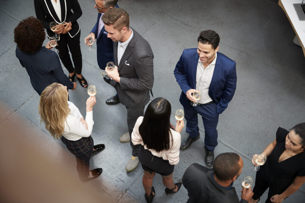 Professionals networking over drinks at a corporate event.