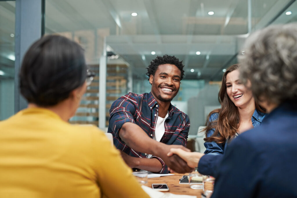 Team member shaking hands with a client, highlighting customer retention management built on trust and long-term partnerships.