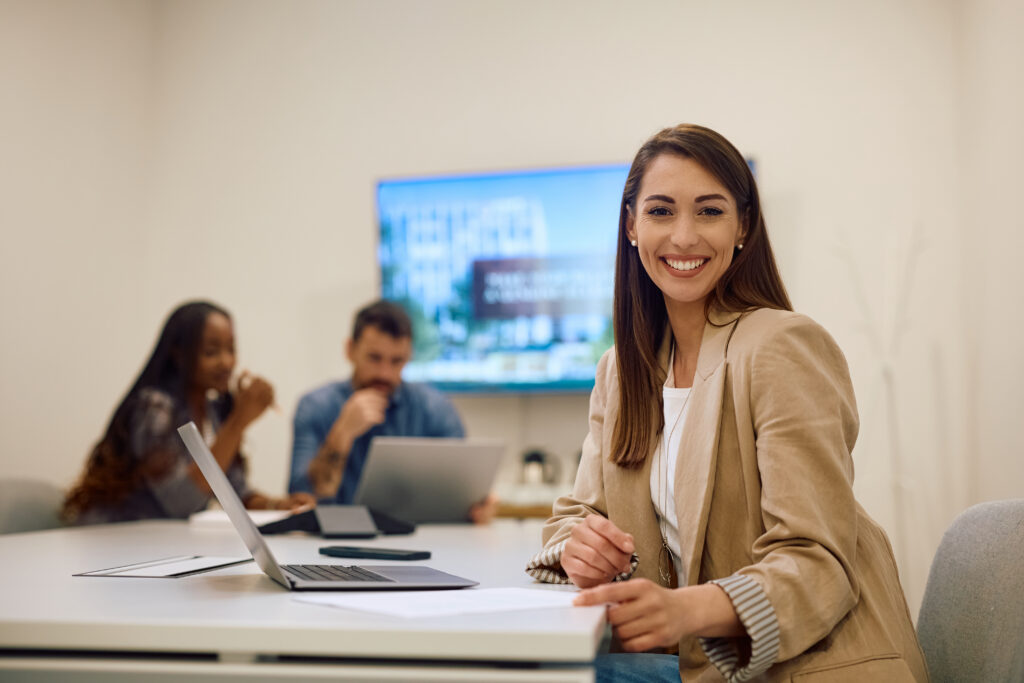 A female marketing intern collaborating with a team in a modern office setting.